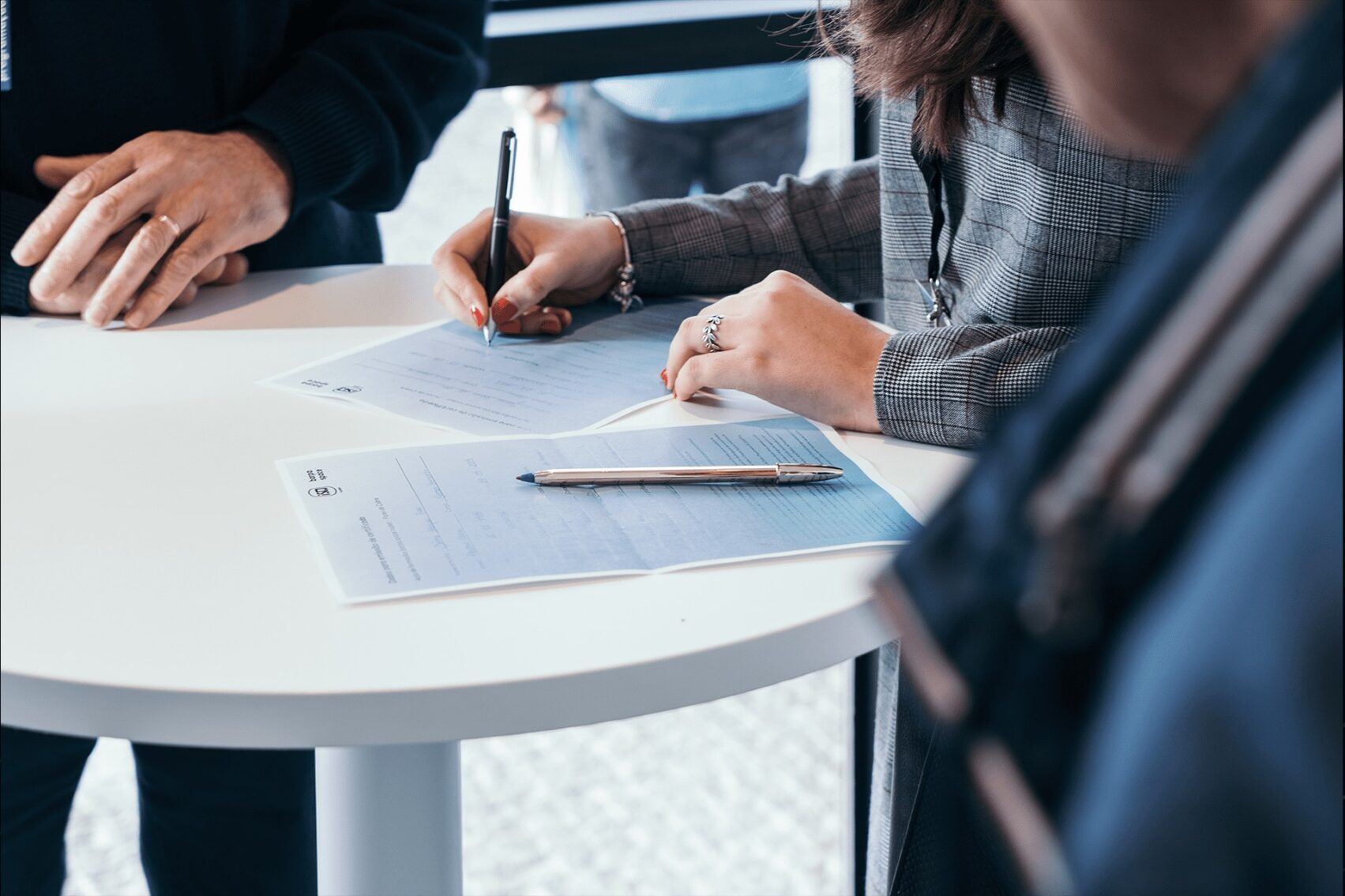 People signing documents on round white table